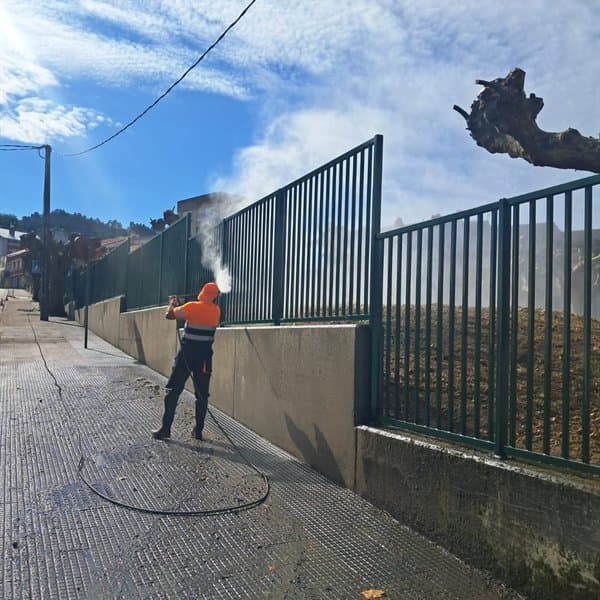 Limpieza con agua a presión de un muro y una verja en el Barbanza