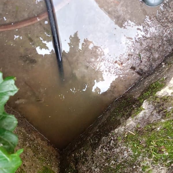 Limpieza con manguera de una arqueta exterior en el Barbanza
